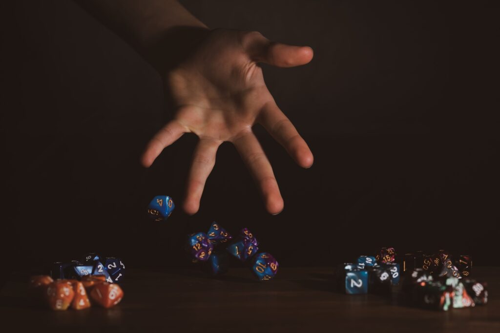 Isolated hand throwing polyhedral dice