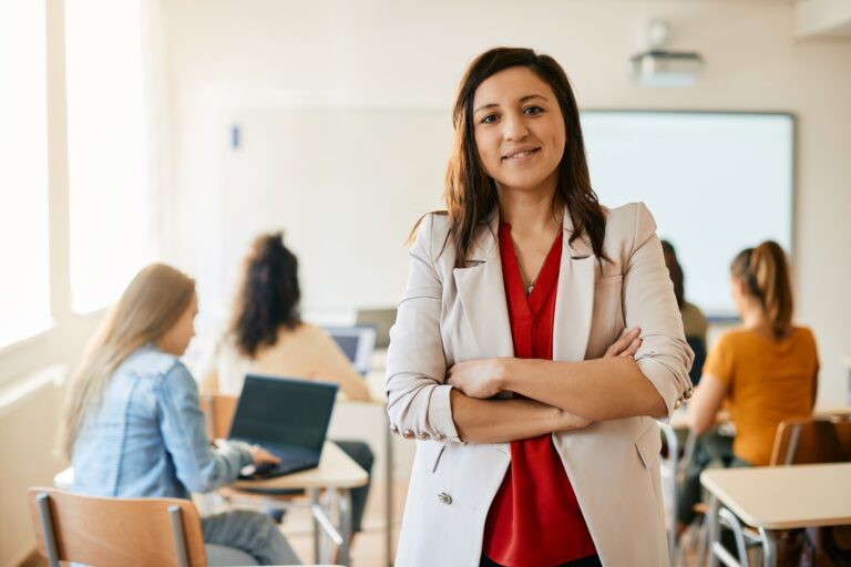 Portrait of confident computer science teacher in the classroom at high school.