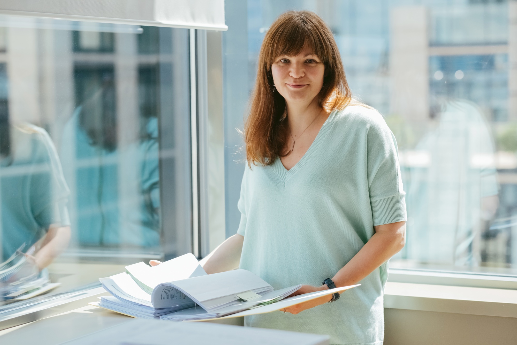 Professional woman reviews papers, embodying confidence and organization.