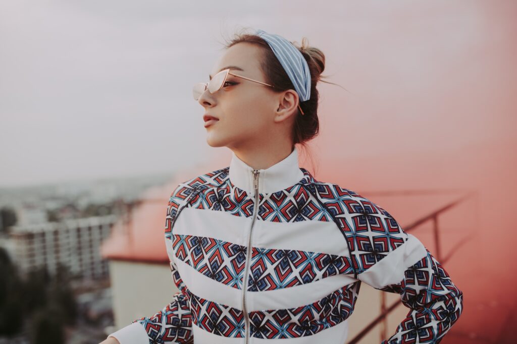 Trendy woman against pink smoke on roof