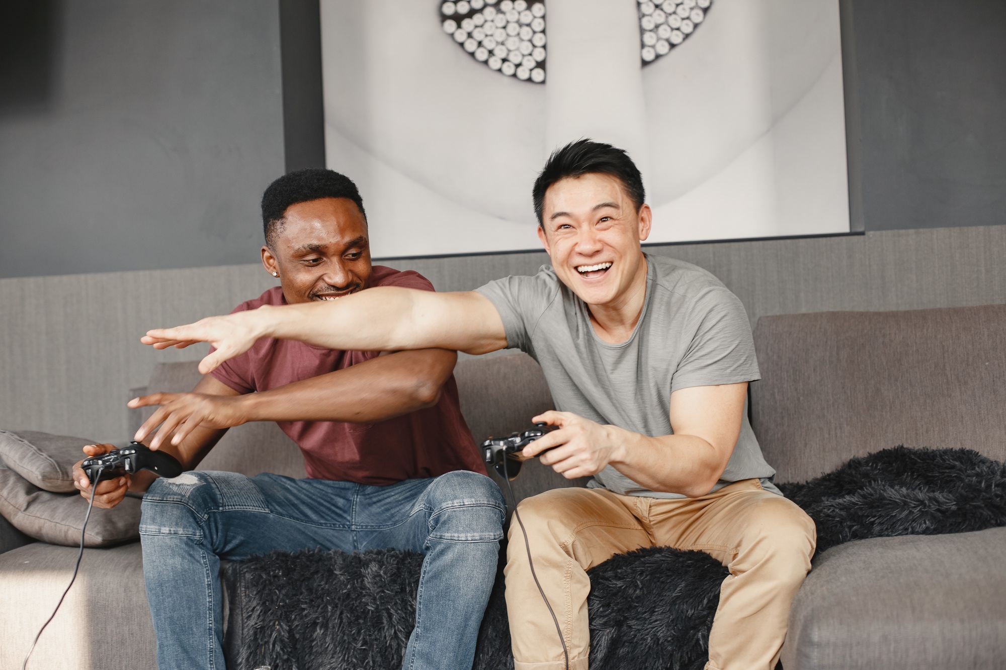 Two friends playing Playstation in the living room