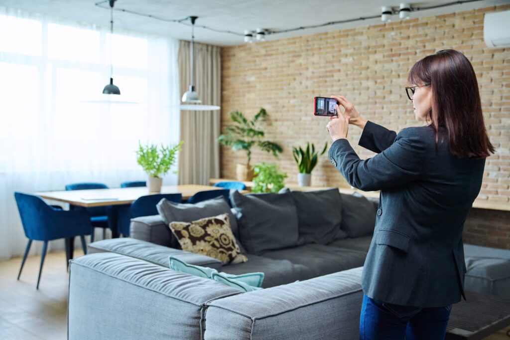 Woman real estate agent photographing furnished apartment