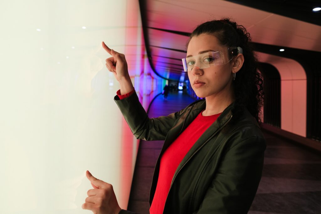 Woman wearing transparent vr headset interacting with transparent screen in metaverse experience