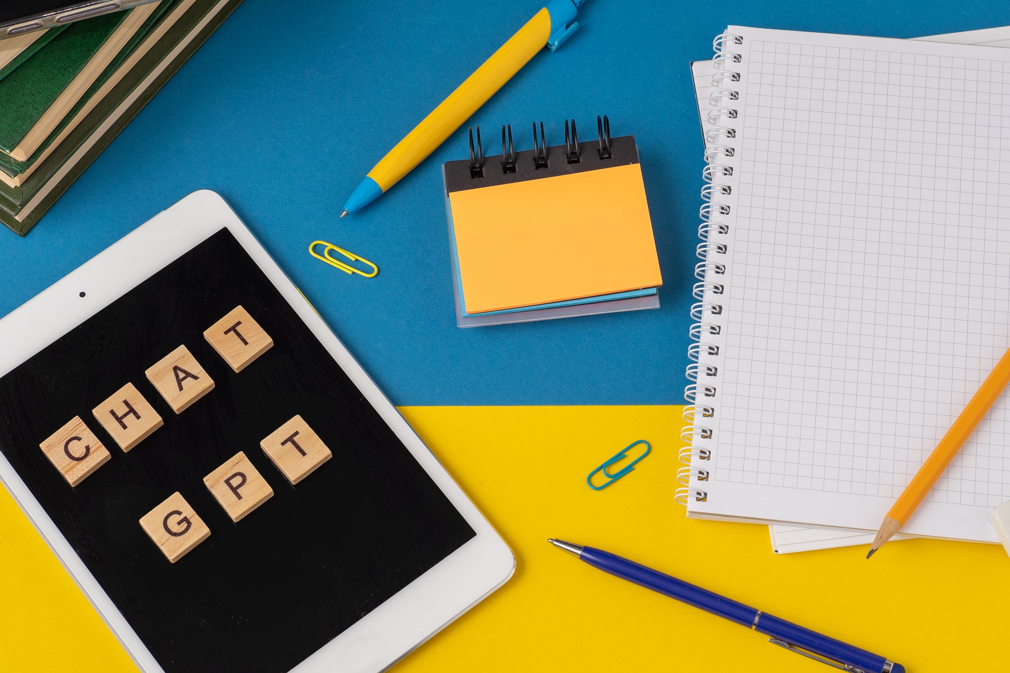 Work and study with the help of a chat bot. Words in wooden letters. Work table with open notebook.