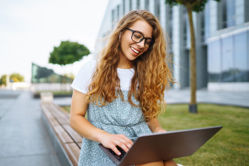 Young woman with laptop outdoor. Education online. Freelancer, Business, shopping, blogging.