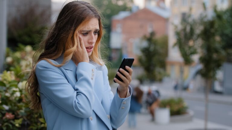 Business woman caucasian girl lady female looking in mobile phone feels shock upset worries about