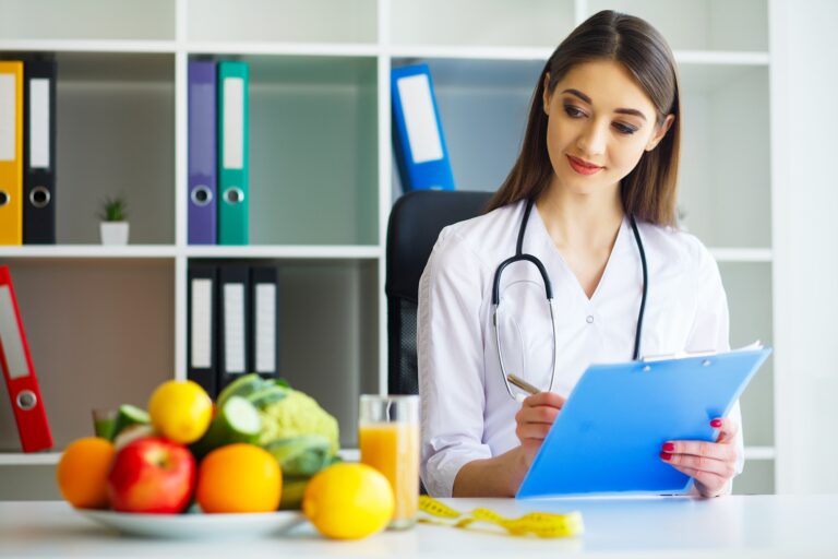 Health. Young Woman Dietitian Sitting At A Table With Fresh Fruits And Vegetables.High Resolution