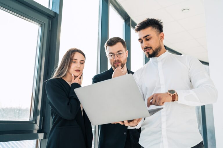 Office workers show company earnings reports on laptop to their boss