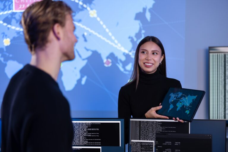 Smiling cyber security team working in a Cyber Security Operations Center SOC to protect systems and