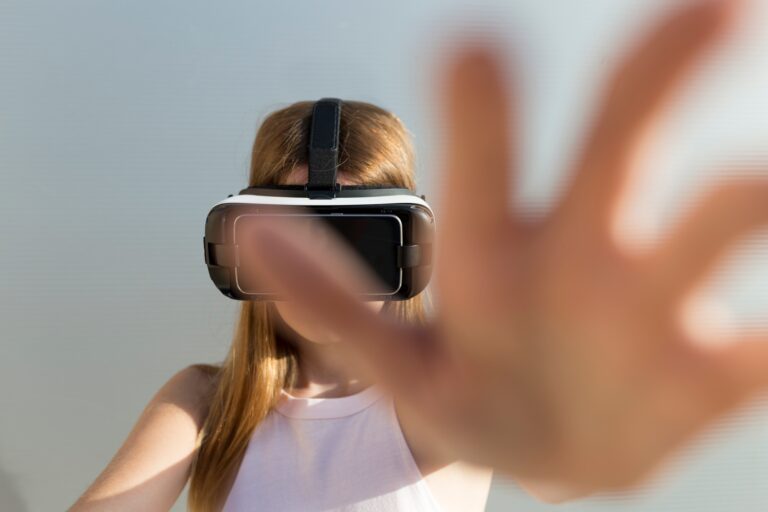 Young woman using Vr googles, reaching with her hand