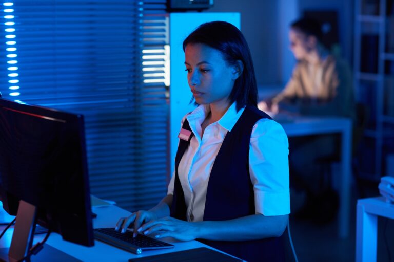 Woman watching surveillance camera feed in dark