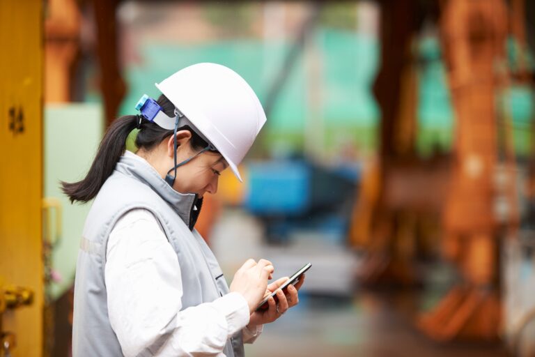 Worker using smartphone at shipyard, GoSeong-gun, South Korea