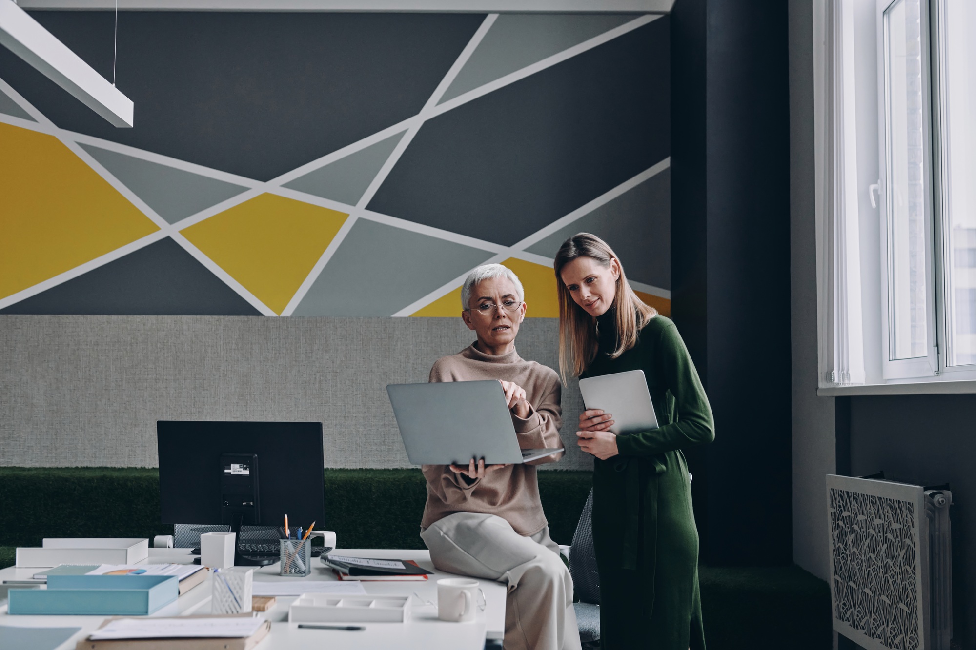 New AI Queen of Wealth on Lucy Guo Woman Billionaire two confident women using technologies and communicating while working in office together