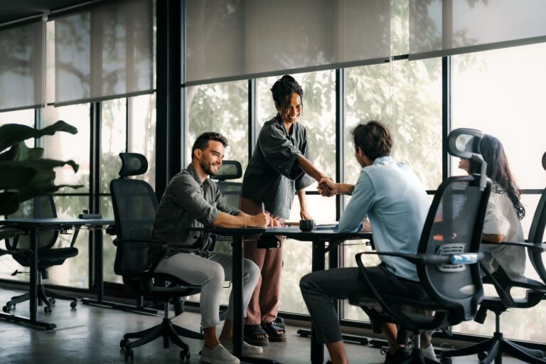 Meeting, partnership and business people shaking hands in the office for a deal, collaboration