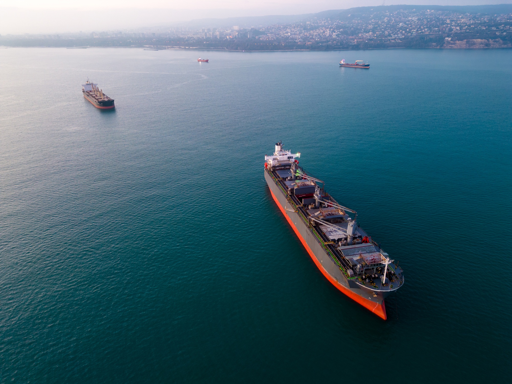 a massive cargo ship wood chips carrier in the sea, aerial view