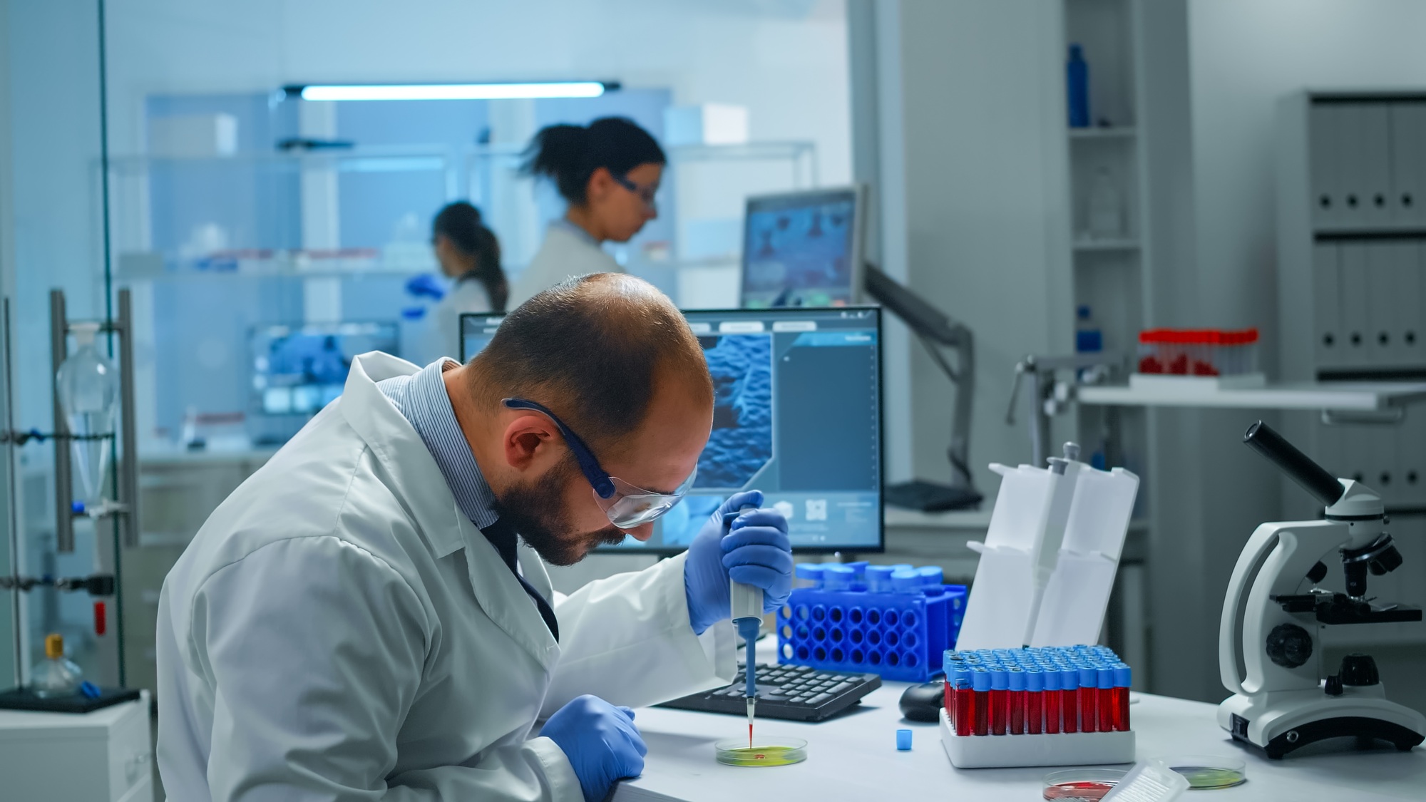 scientist examining drug discovery putting blood sample in petri dish with micropipette