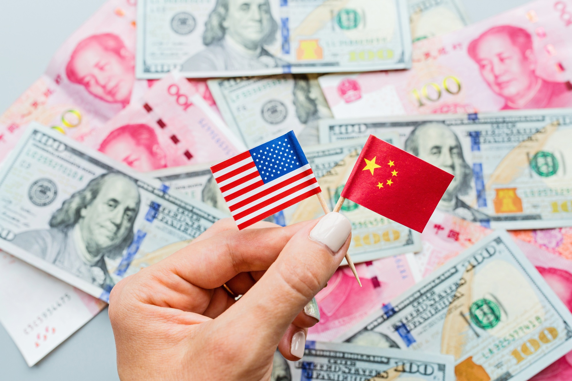 woman holding hand flags of china and usa america, on background lying cash money