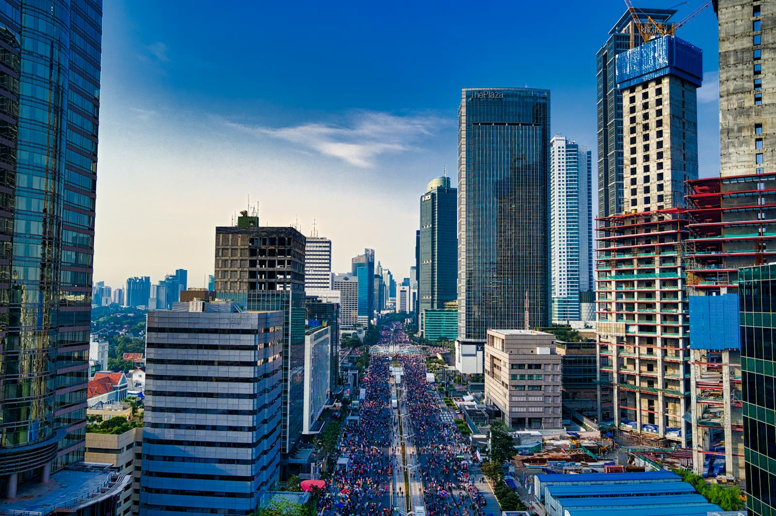 The New Silent Revolution: Why AI Is Making Us Richer — and Yet More Uneasy Stunning aerial view of Jakarta's modern skyline with bustling streets below.