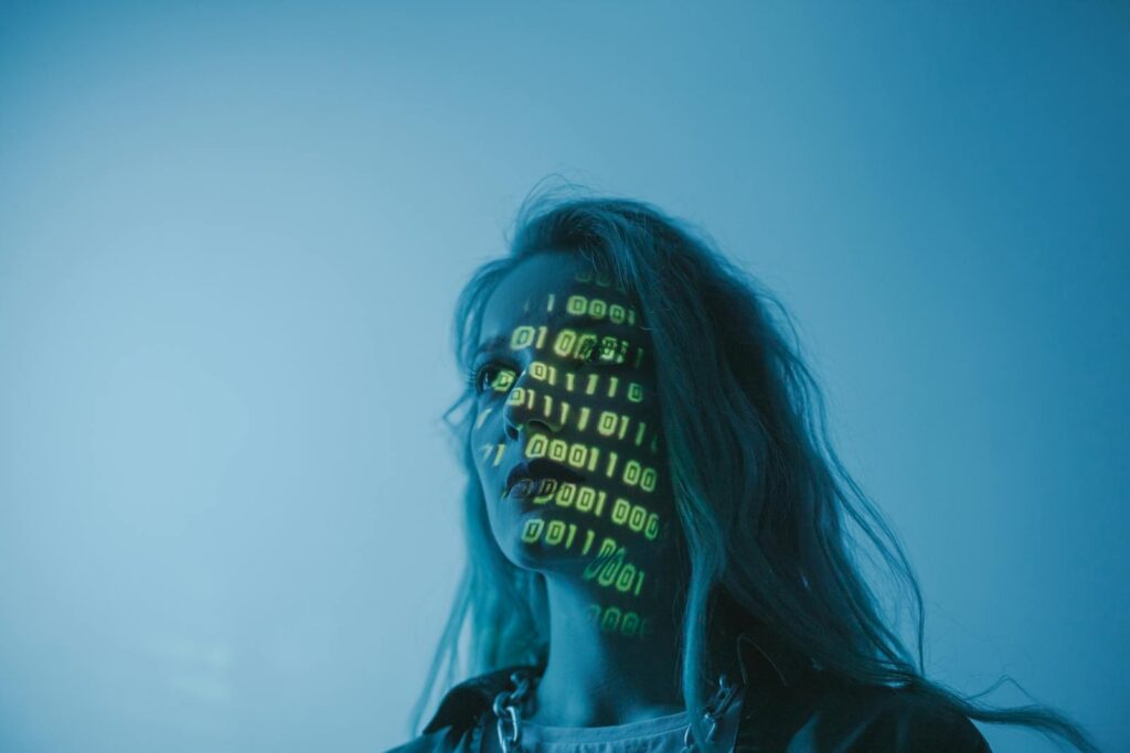 Why Your New AI Chatbot Might Be Lying to You A woman with binary code lights projected on her face, symbolizing technology.
