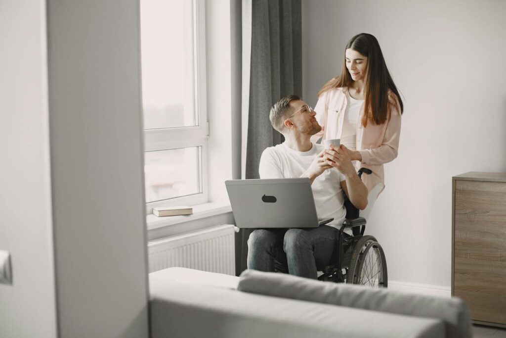 A couple enjoys a moment together with a laptop, highlighting love and support indoors.