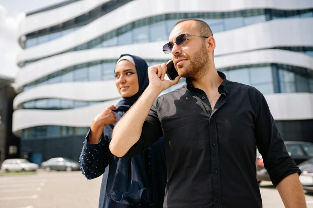 The New AI Hiccup Before Davos: What’s Really Going On? Business professionals conversing outdoors against modern architecture, embracing urban lifestyle.