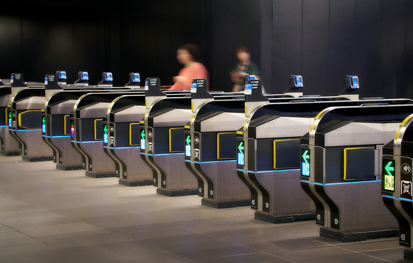 People passing through modern ticket gates in a station.