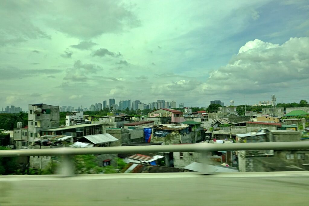 Distant city skyline behind urban sprawl under cloudy sky