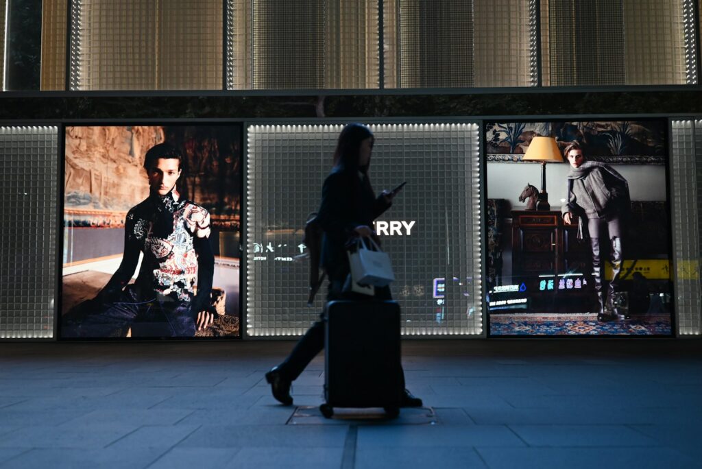 Why Google Cast a Turkey for First Fully New AI-Generated Ad Person walks past illuminated fashion displays at night.