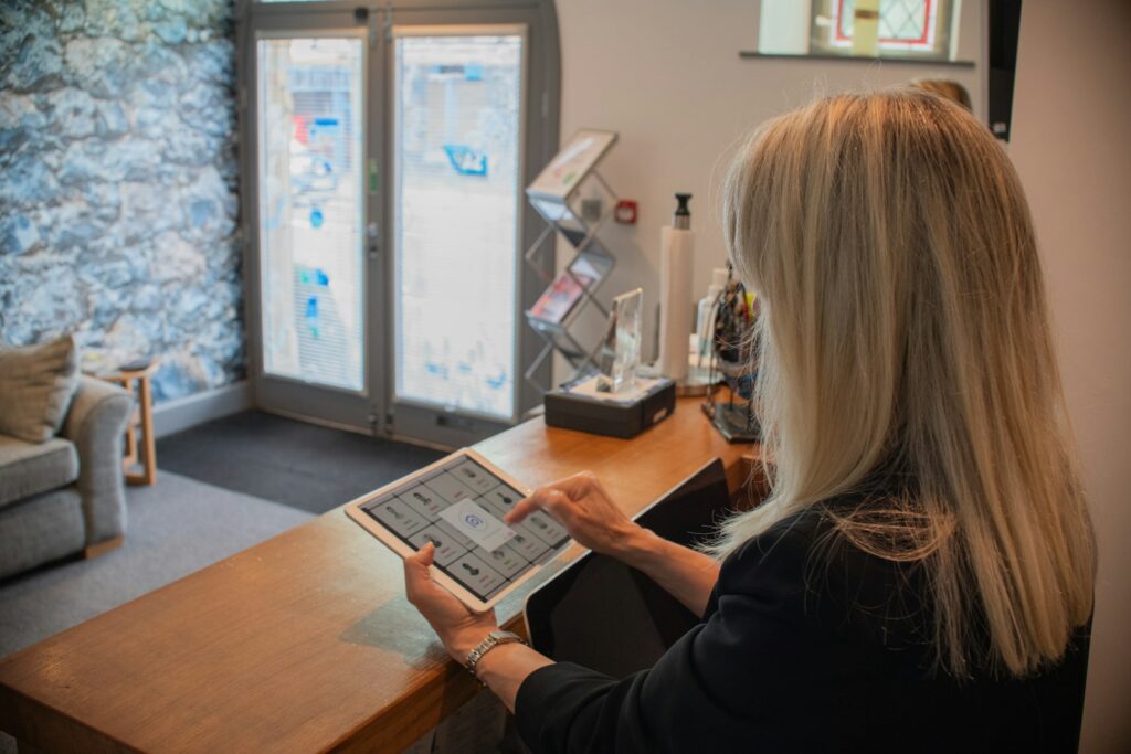 Woman using a tablet at a reception desk.