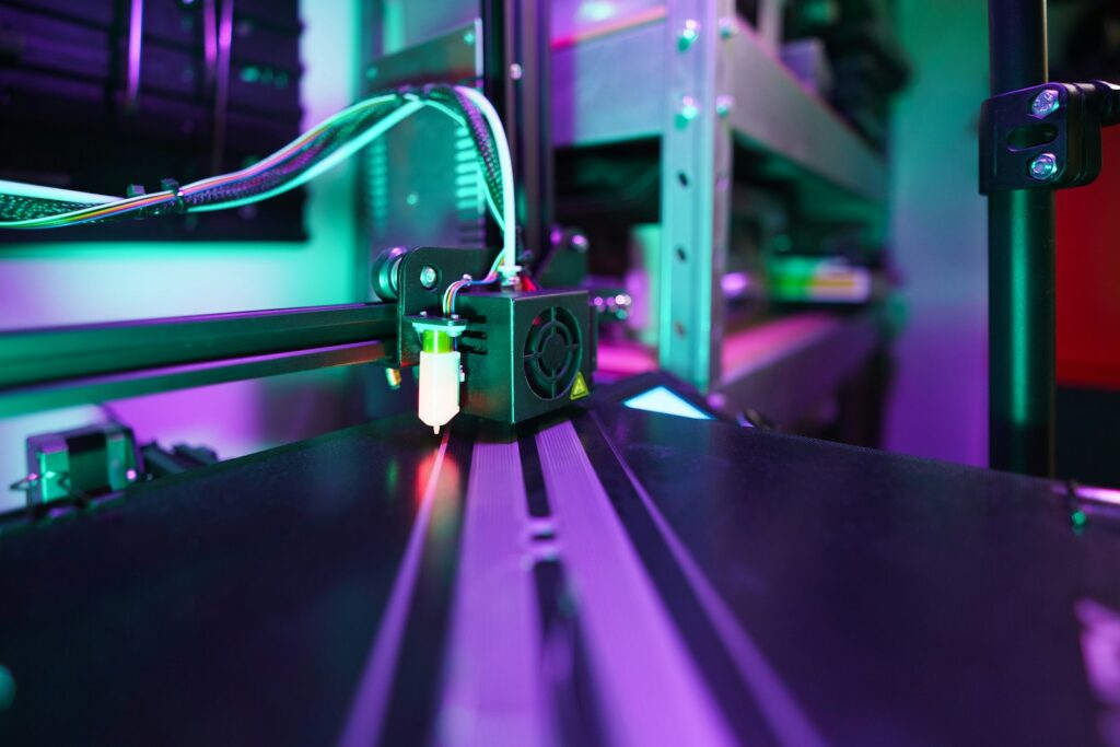 3D printer head creating object with purple and green lights