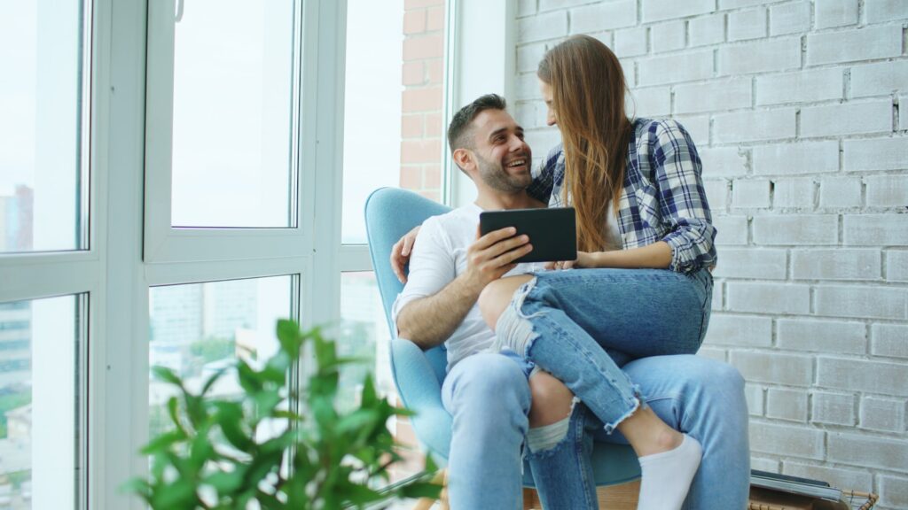 Couple looking at tablet together in armchair