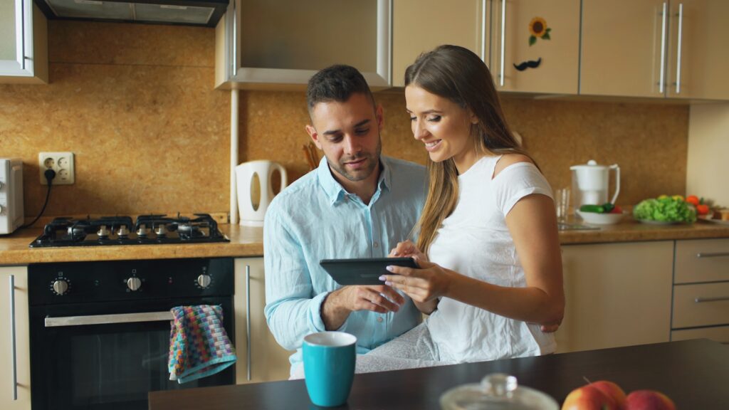 Couple looking at tablet in modern kitchen