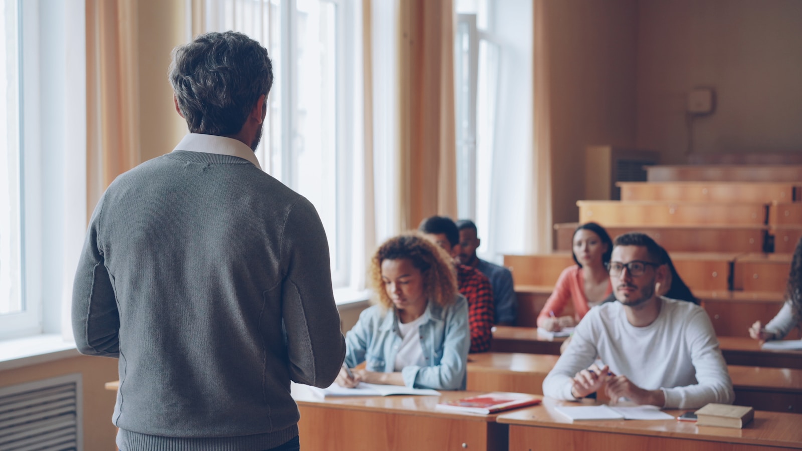 Professor teaching students in a lecture hall.
