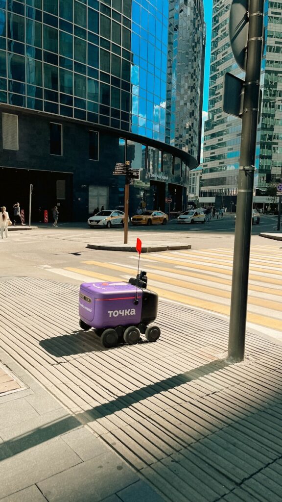 A purple suitcase sitting on the side of a road