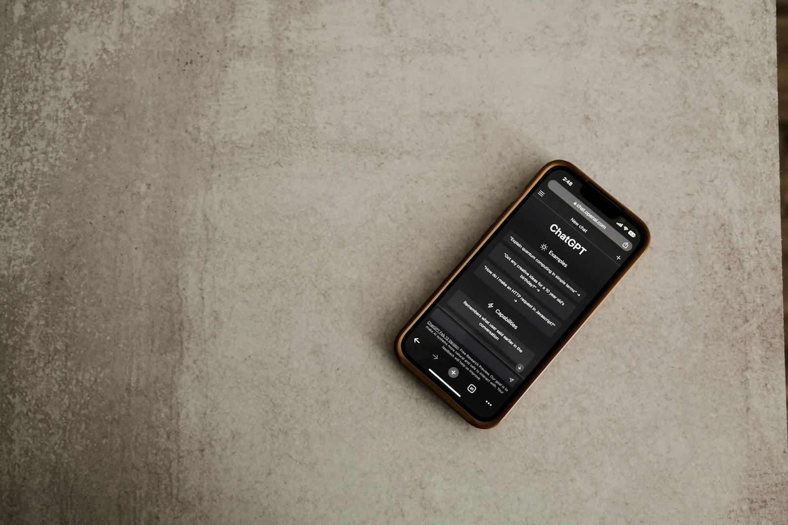 The New Battle for AI Dominance on ChatGPT AI Revolution Close-up of a smartphone with the ChatGPT app open, highlighting AI technology on a textured surface.