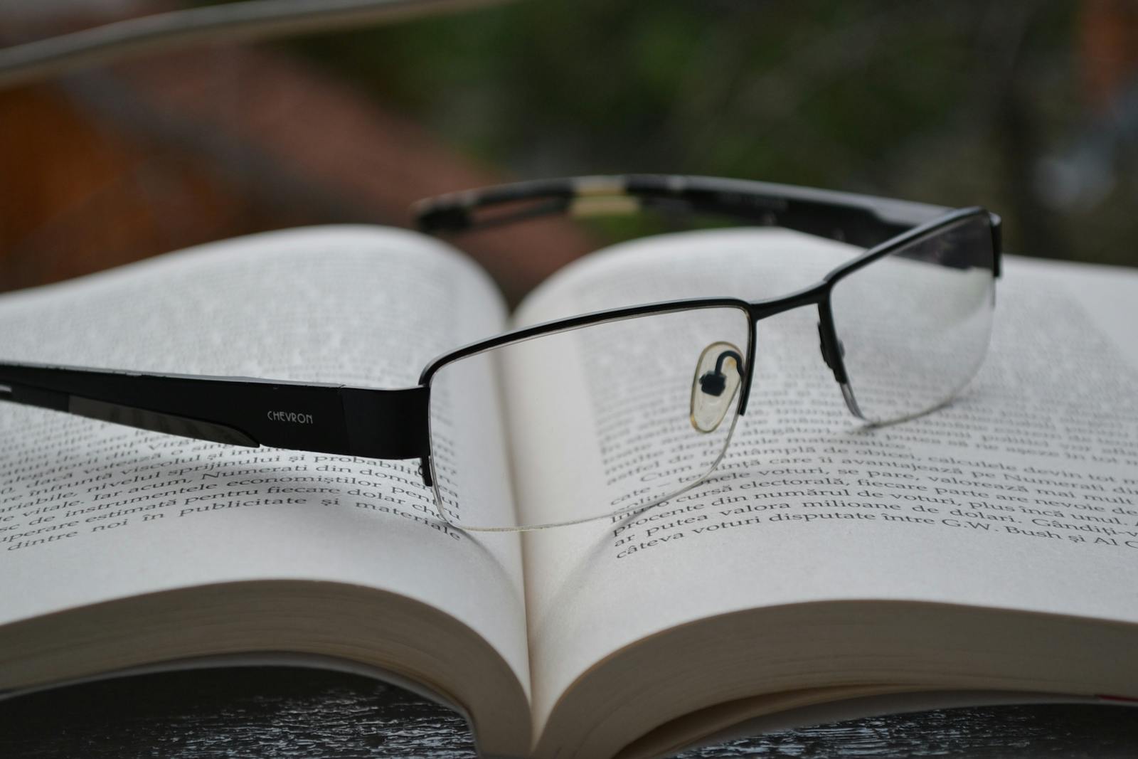 Eyeglasses resting on an open book, symbolizing knowledge and learning.