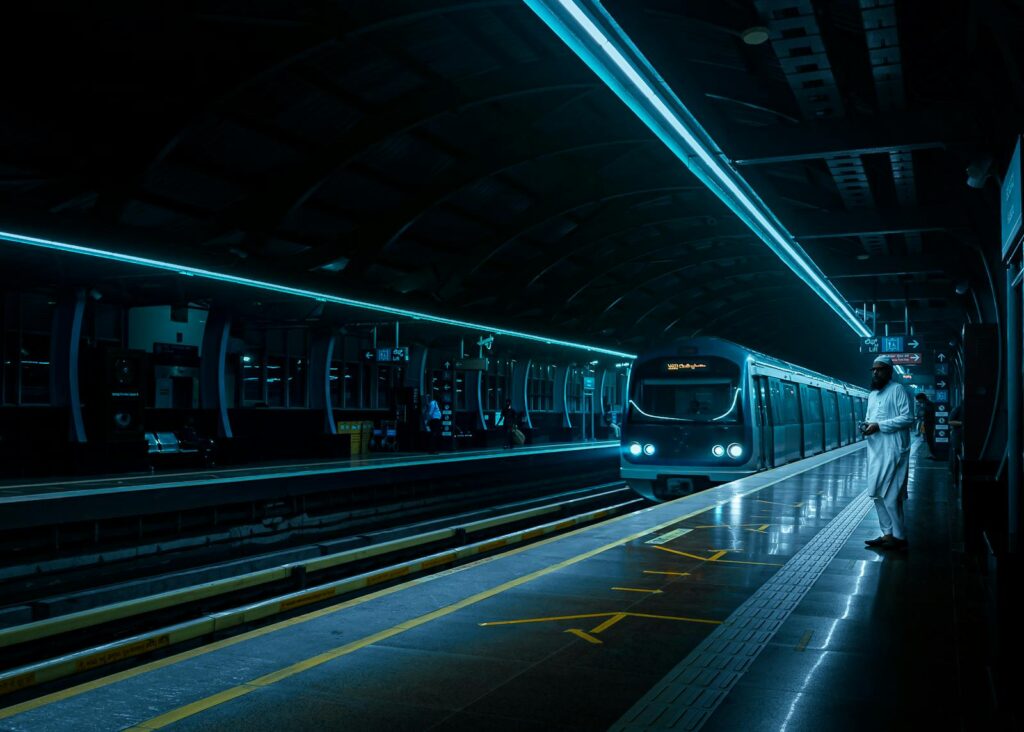 Dramatic night view of a metro station in Bengaluru with futuristic lighting and a modern train.