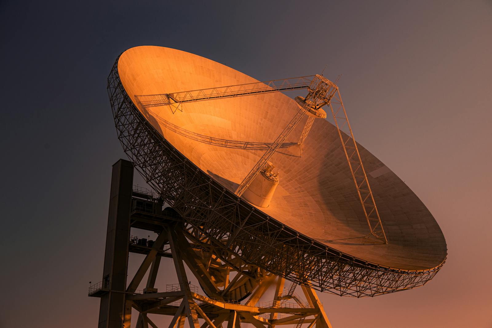 Why Tech Giants Want Data Centers in Space A striking satellite dish basking in golden hour light, capturing signals from space.