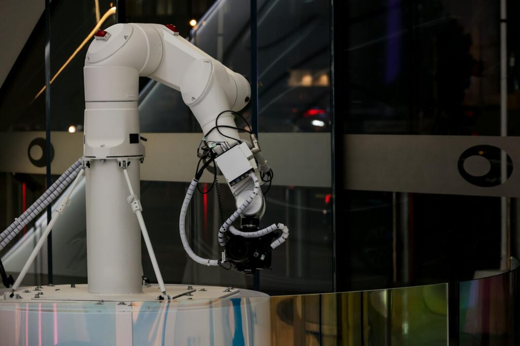 A white robotic arm operating indoors with a modern design and advanced technology.
