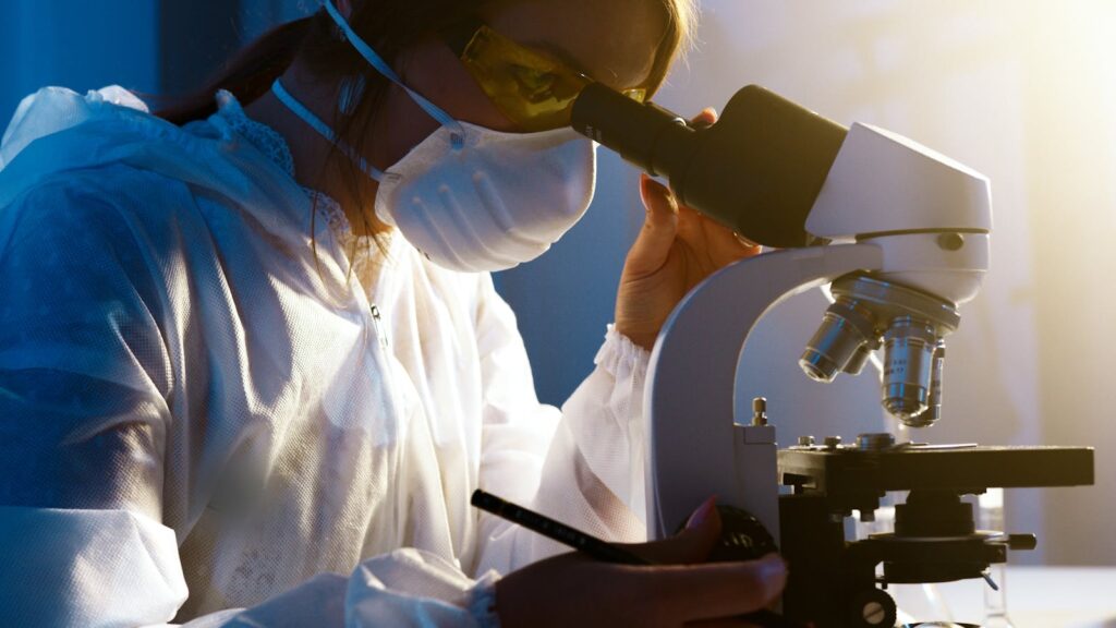 A female scientist uses a microscope in a laboratory, focusing intently on her research.