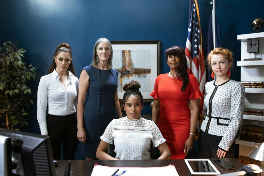 A group of confident, professionally dressed women in an office setting, showcasing empowerment and diversity.