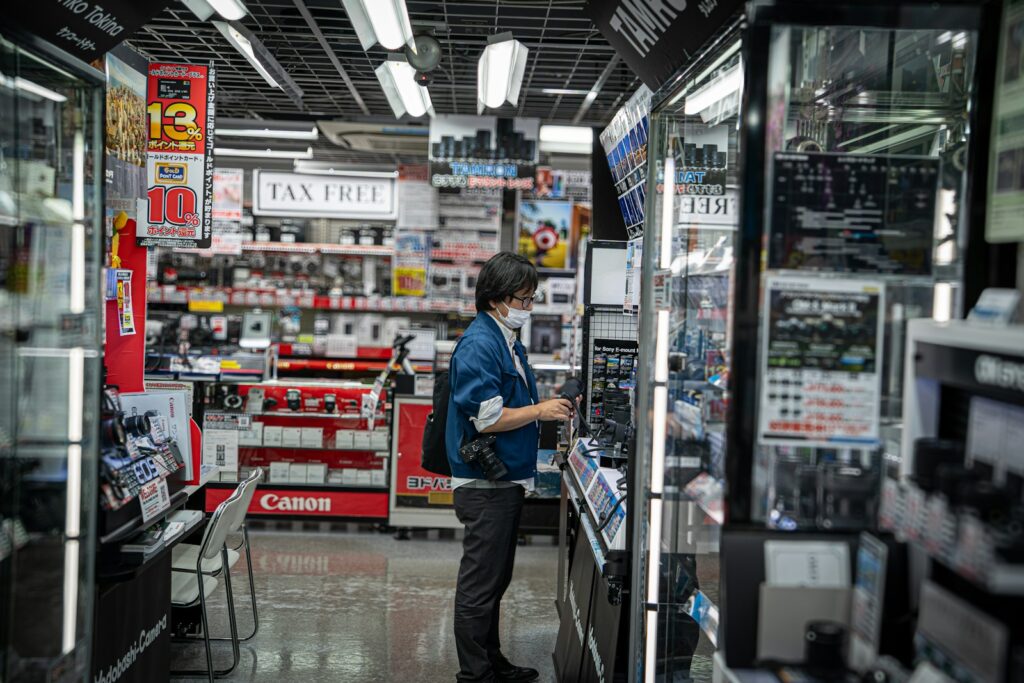 How New AI Disrupting Shopping and What Means for You Person browsing electronics in a brightly lit store.