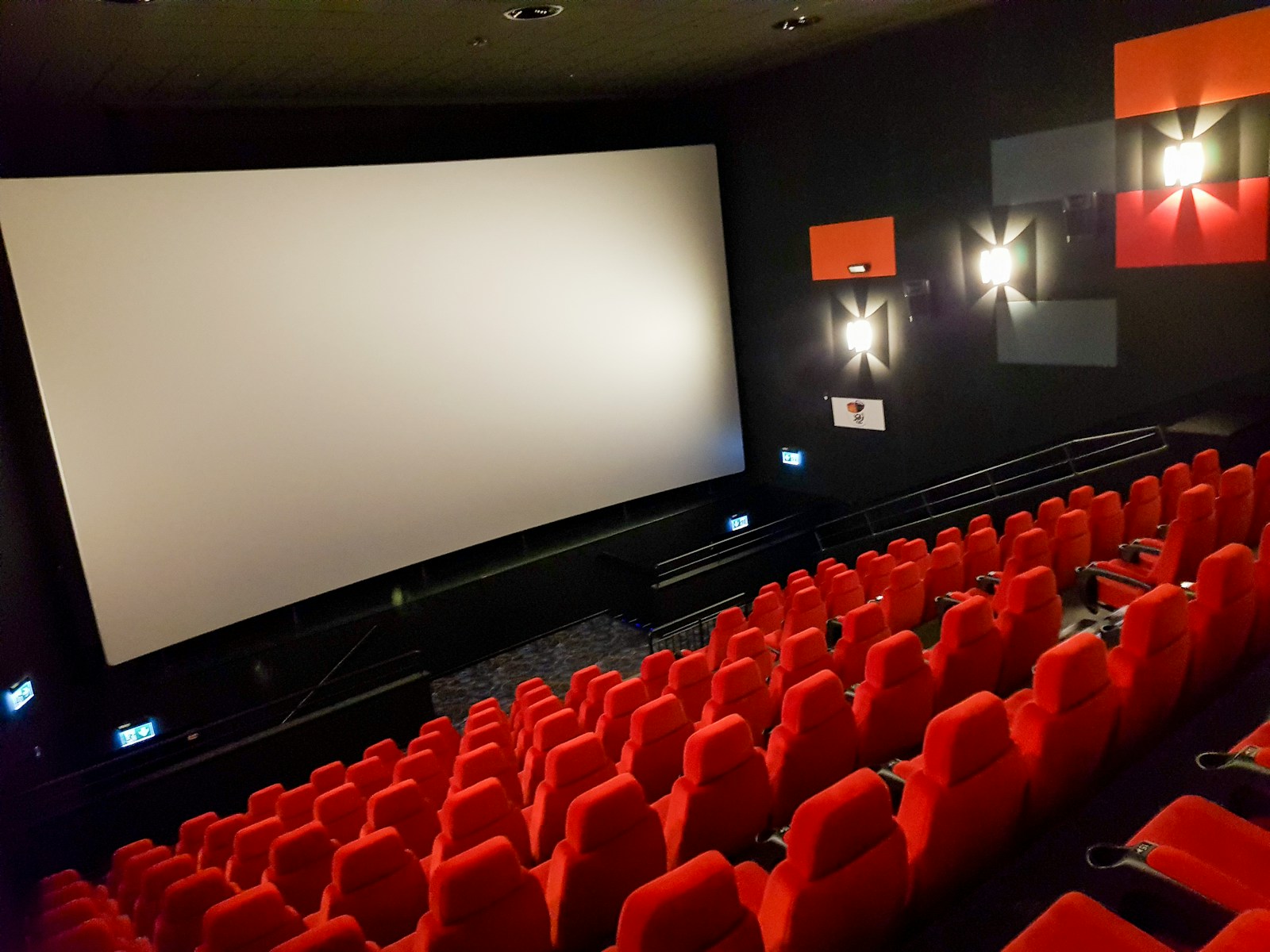 Lights, Camera, Algorithm: How New AI Is Transforming Indian Cinema an empty theater with red seats and a projector screen