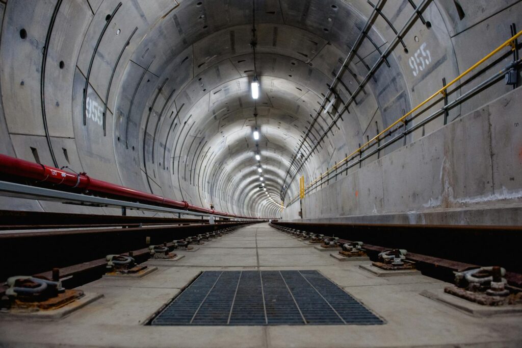A modern underground subway tunnel showcasing curved architecture and railway tracks.