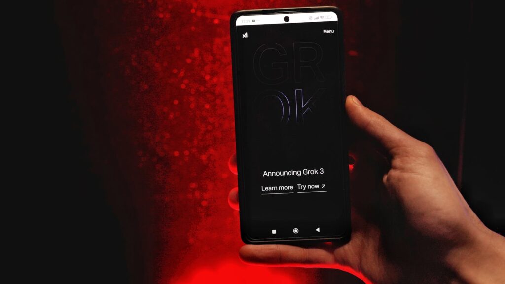 Why Grok AI Sparked a New Global Debate About Consent A hand holds a smartphone displaying Grok 3 announcement against a red background.
