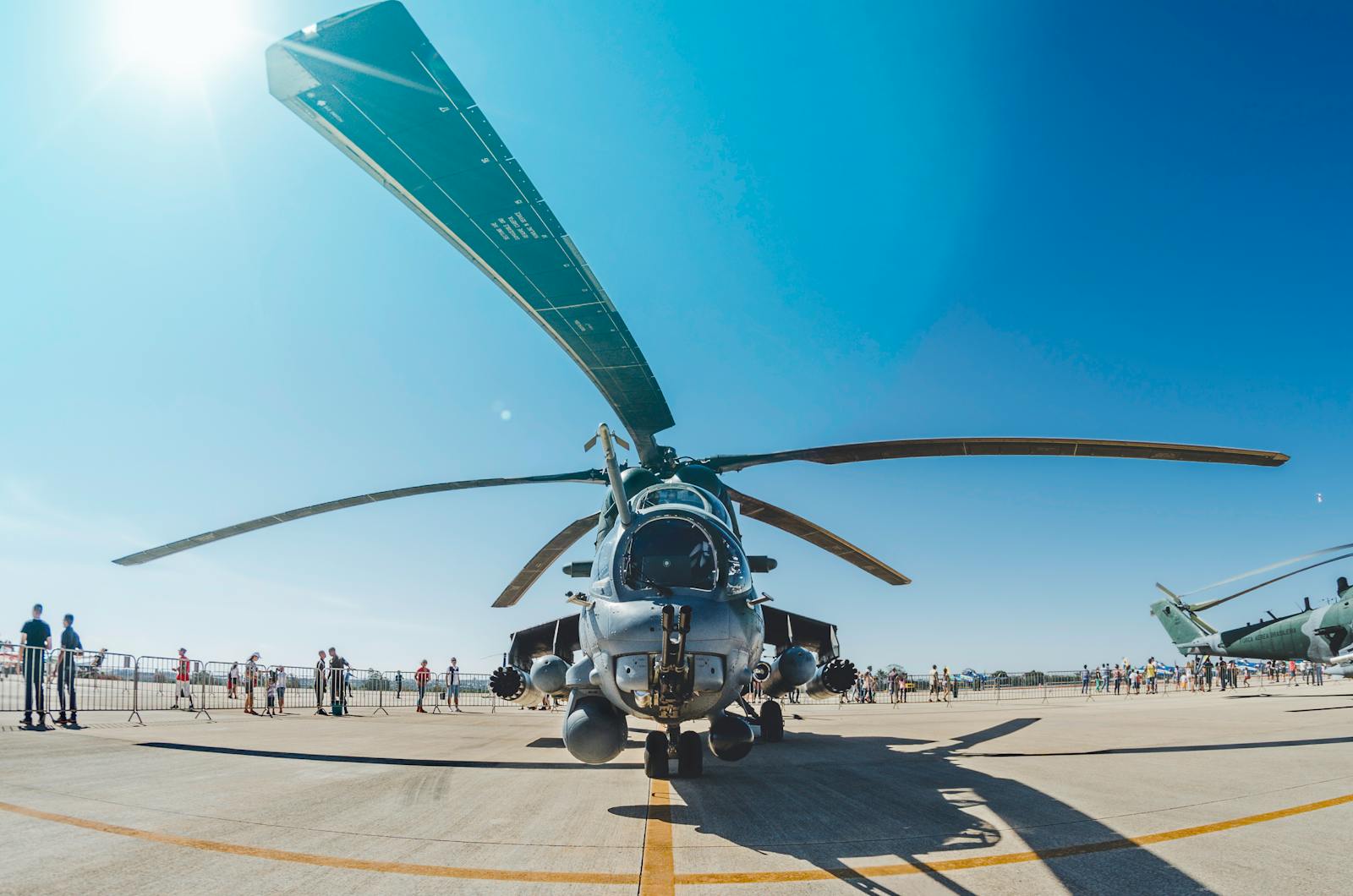 Front view of a military helicopter at an airshow in Brasília, capturing the crowd and bright sun.