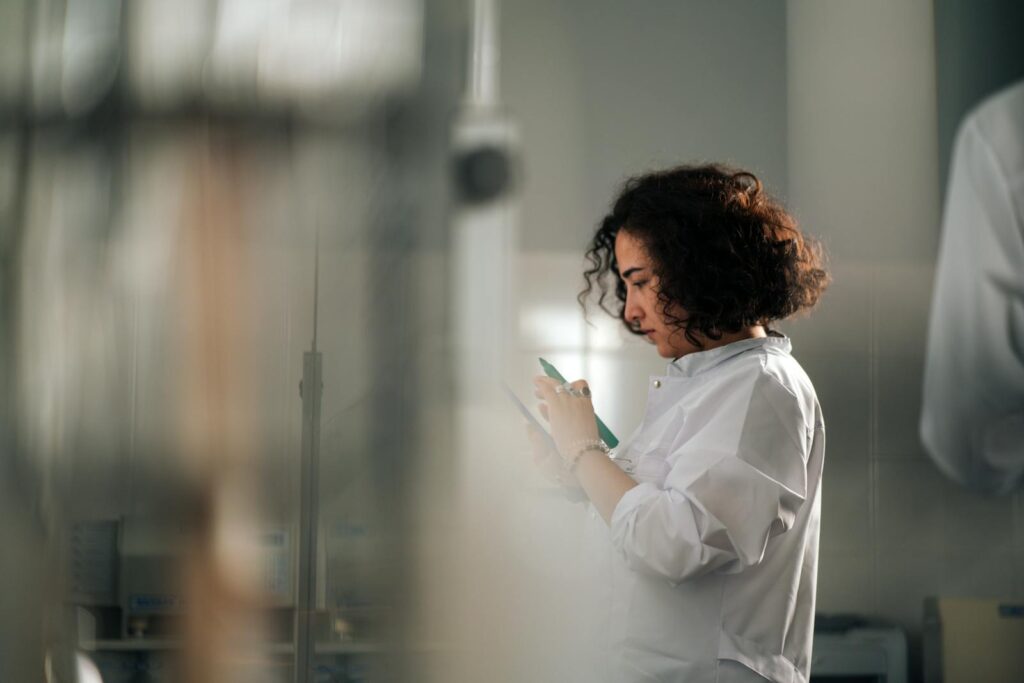 The 10 New Breakthrough Technologies of 2026 and How They’re Quietly Reshaping the World A focused female scientist with curly hair writes notes in a laboratory setting.