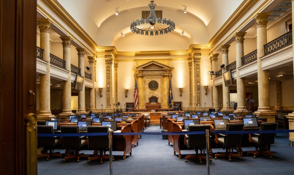 Even AI’s Biggest Winners Are Hitting the New Brakes A grand government chamber with elegant columns and seating. Perfect for politics or architecture themes.