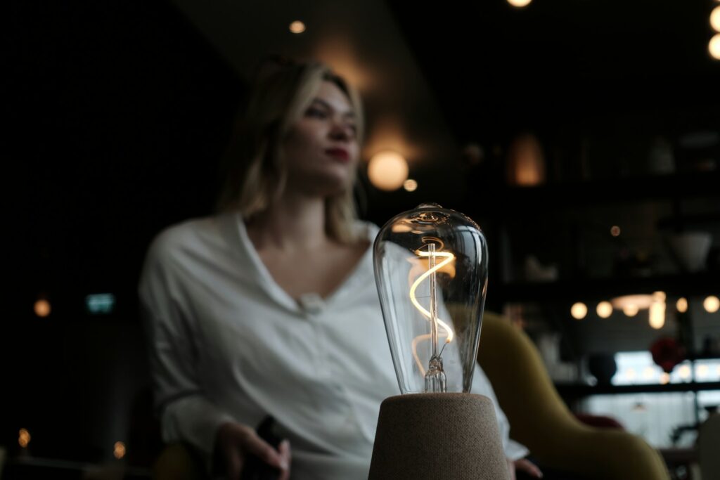 Woman in white shirt with illuminated edison bulb