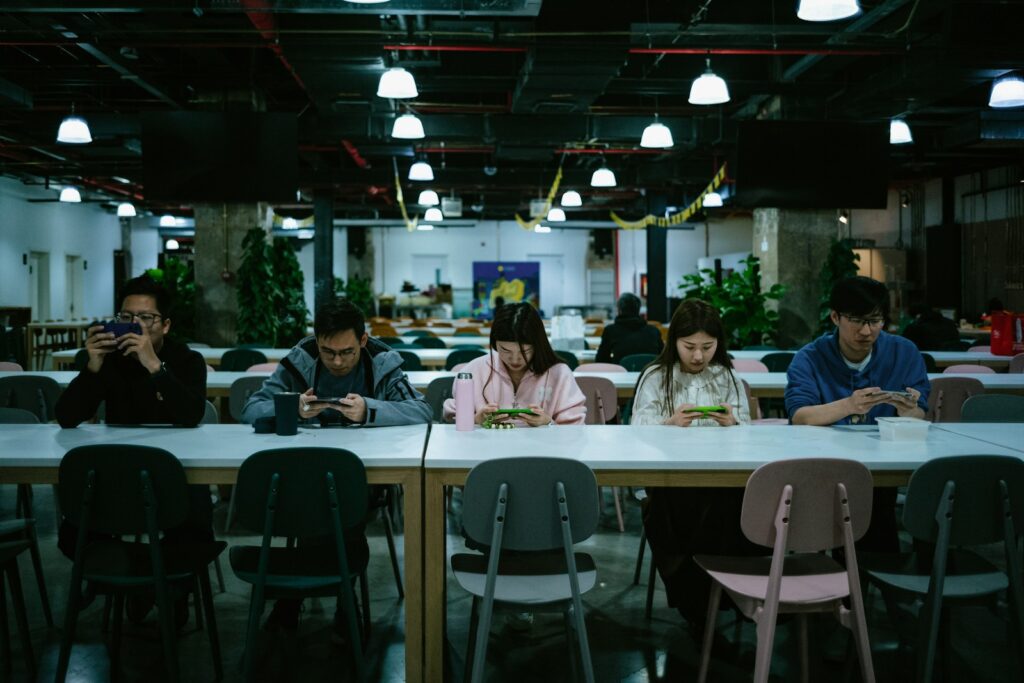 a group of people sitting at a table with cell phones